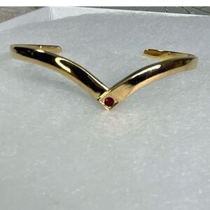 Avon gold tone V shaped cuff bracelet with faux ruby or garnet. Large